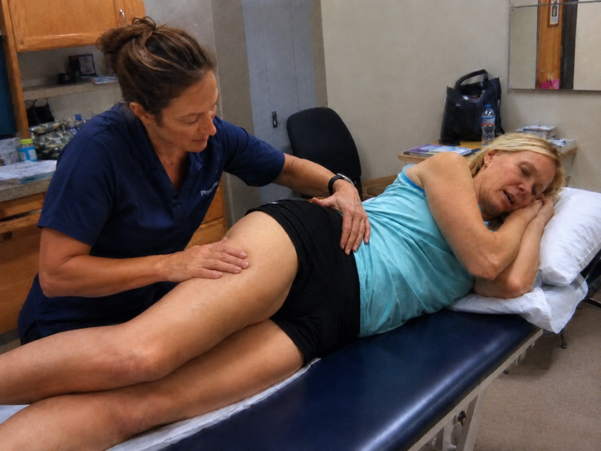 Physiotherapist assessing the outside of a patient's hip
