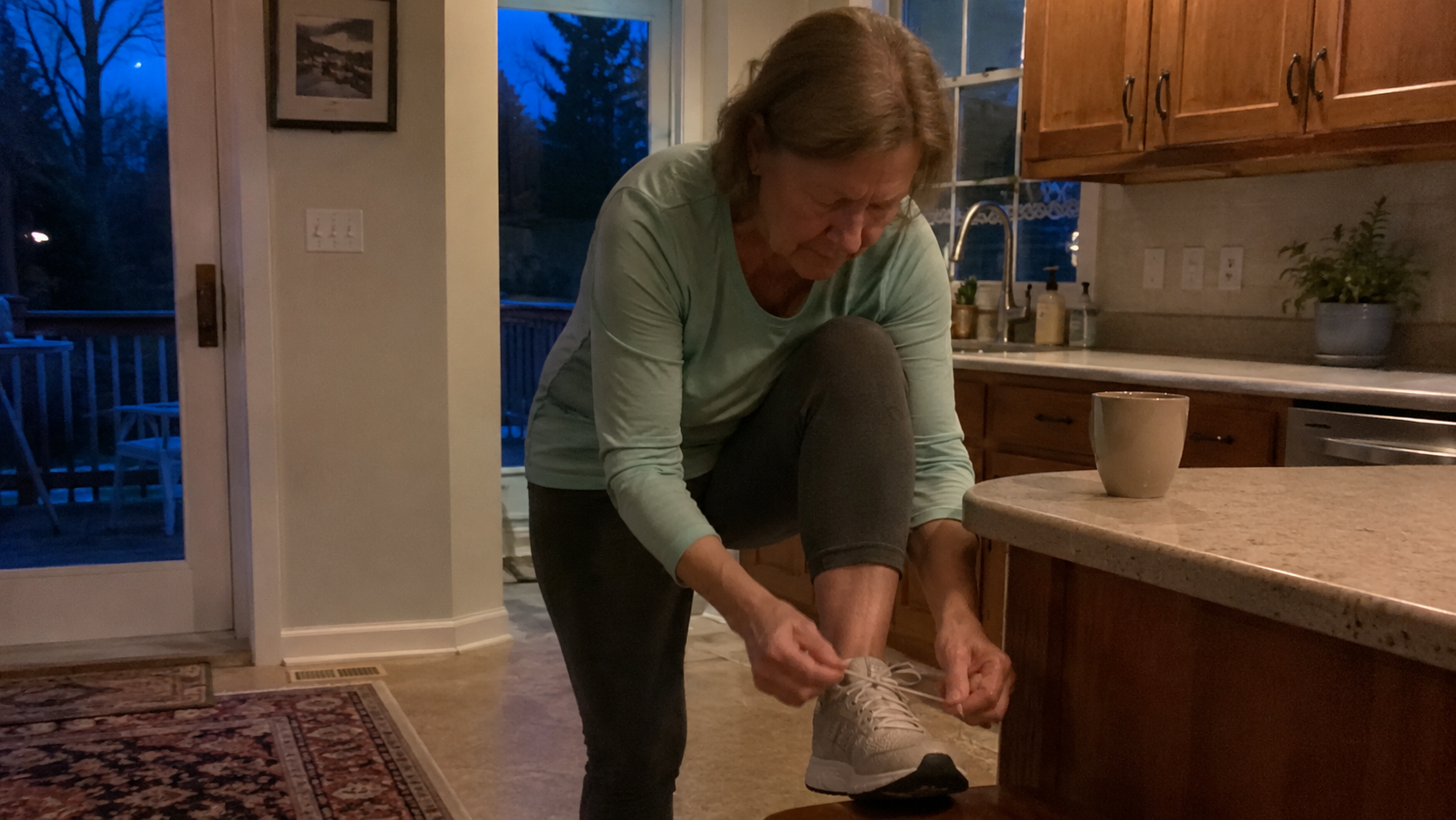 A woman lacing her walking shoes early in the morning
